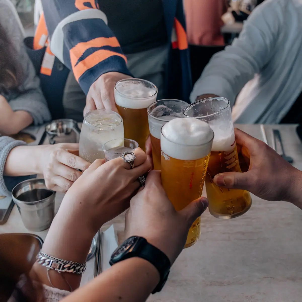 Groupe d'amis trinquant avec des boissons lors d'un rassemblement convivial et festif