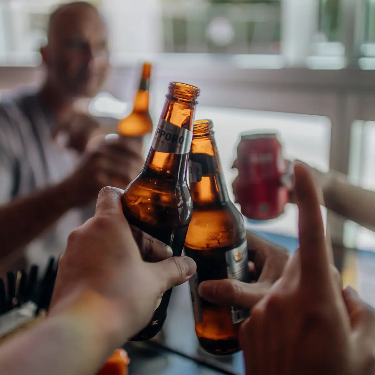 Des amis trinquent lors d'un rassemblement convivial en intérieur, ambiance festive de dégustation entre proches